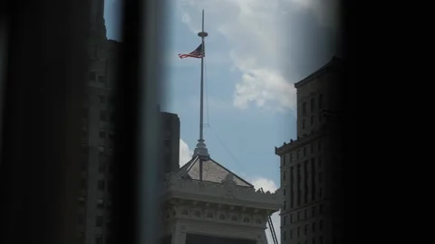 American Flag through a window on top of old beautiful building Stock Footage 161810707