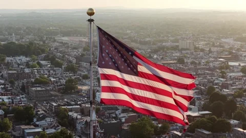 American flag waves above small town rooftops across United States, white Stock Footage 340969948