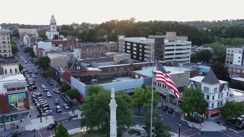 American flag waves beside stone monument in downtown Easton square Stock Footage 339908013