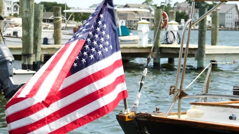 American flag waves on a boat docked in a coastal marina Stock Footage 281817191