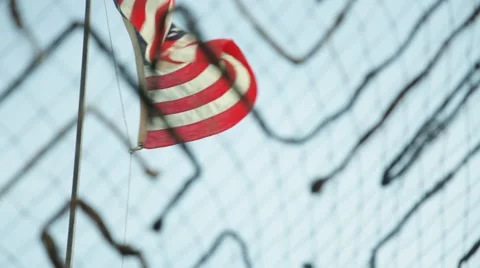 American Flag Waves in the Breeze Behind Camoflauge Netting Stock Footage 41254802