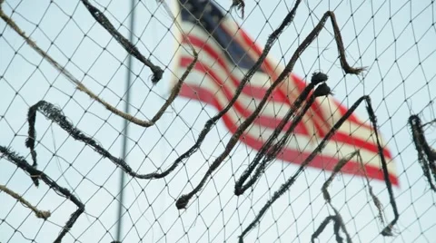 American Flag Waves in the Breeze Behind Camoflauge Netting Stock Footage 41254808