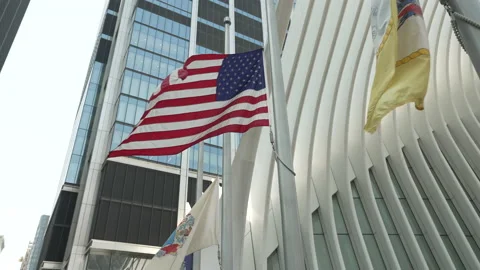 American Flag waves at half mast in front of the World Trade Center oculus Vídeos de archivo 181218443