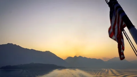 American flag waves over an alaskan fjord in Kenai Vídeo Stock 120173388