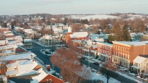 American flag waves over small town in USA. Winter snow. Aerial Vídeos de archivo