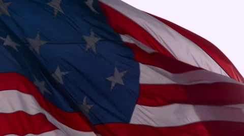 An American flag waves in slow motion with the sun behind. Stock Footage 41981870