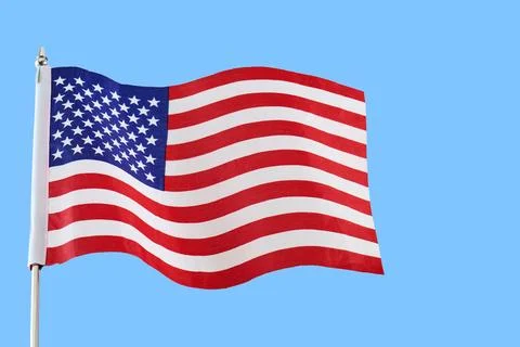 American flag waving in blue sky representing patriotism 스톡 사진