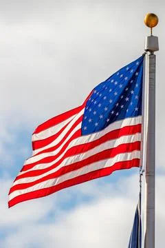 American flag waving with clouds in the background Stock Photos