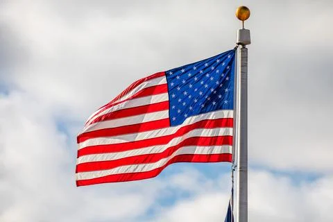 American flag waving with clouds in the background Stock Photos