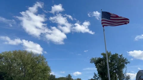American Flag Waving on Flagpole Against Blue Sky with Clouds Stock Footage 345366298