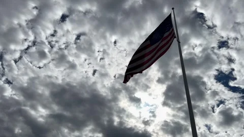 American Flag Waving on Flagpole Below Dramatic Overcast Sky Stock Footage 344769464