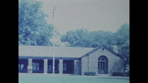American flag waving in front of a building in lake george, 1961 Stock Footage 326896410