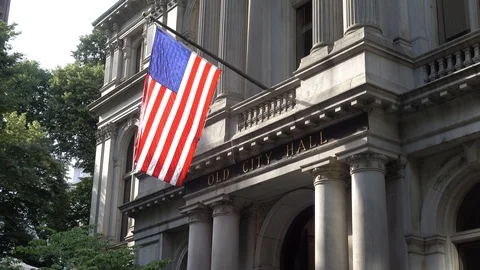 An American flag waving in front of the facade of a building in Boston Stock Footage 93439171