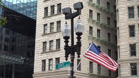 An American flag waving in front of the facade of a building in Boston Stock Footage 93439403