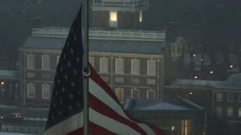 American flag waving in front of Independence Hall, surrounded by fog and light Vídeo Stock 328354733