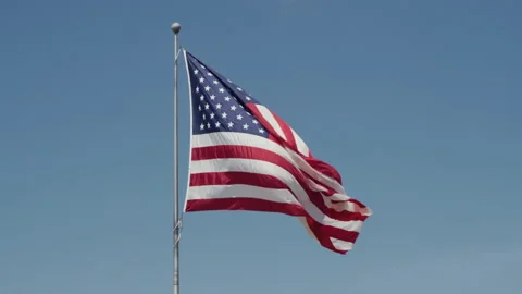 American Flag Waving on Pole in The Wind Against Blue Sky Vídeos de archivo 277536701