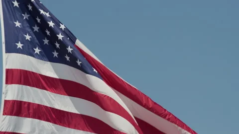 American Flag Waving on Pole in The Wind Against Blue Sky 動画素材 277536769