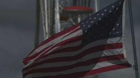 American Flag Waving in Slow Motion with Ferris Wheel in background Stock Footage 82364340