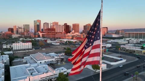 American flag waving at sunset in Phoenix, Arizona. Cinematic aerial orbit 動画素材 255755776