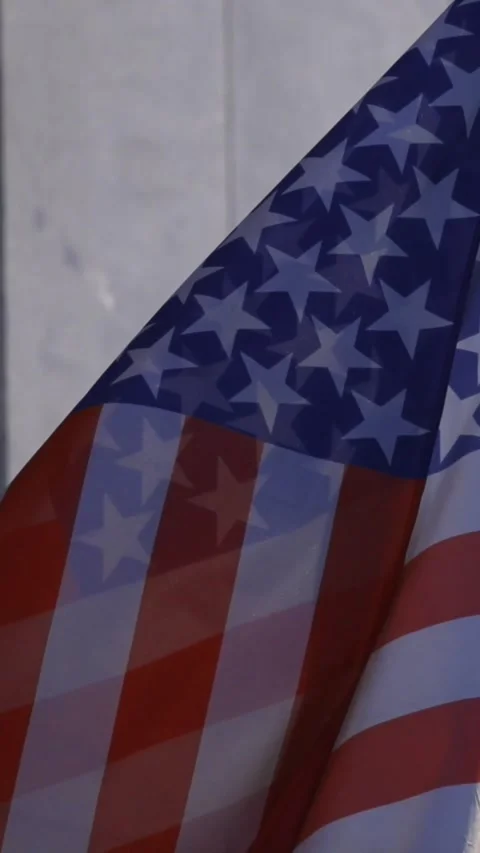 American flag waving in the wind against a modern building Stock Footage 327809739