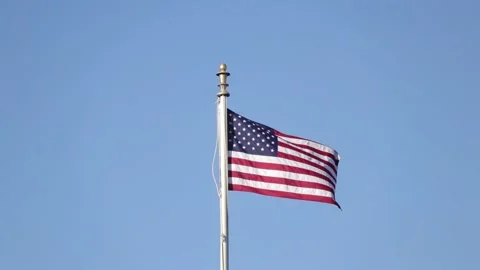 American flag waving in the wind with clear blue sky Stock Footage 171125435