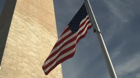 American flag wavy wind blowing at the base of washington monument in DC Stock Footage 122131760
