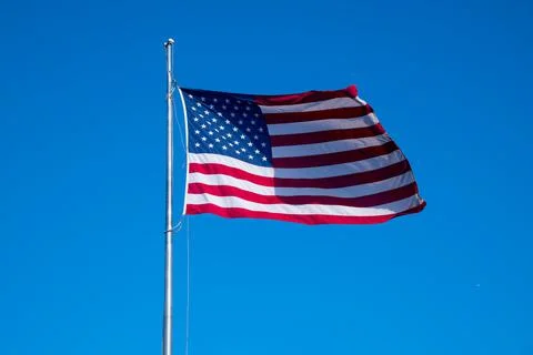 American flag in the wind on blue background Stock Photos