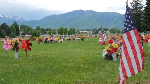 American flags and decorations over graves at a cemetery. Stock Footage 91611258