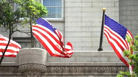 American Flags blowin in the wind on the front of the Trump Hotel in DC Stock Footage 77188160