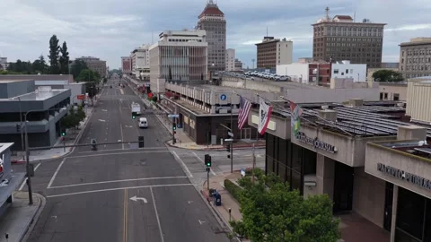 American flags fly above business storefronts along empty downtown Fresno Stock Footage 339908032