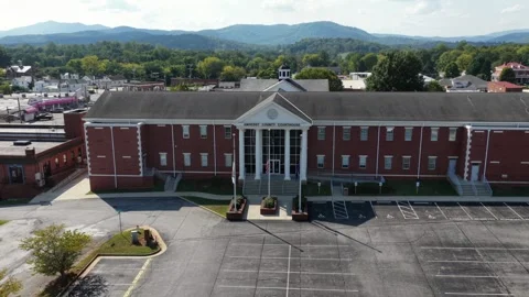 American flags fly before red brick Amherst County Courthouse, white columns Stock Footage 345727614