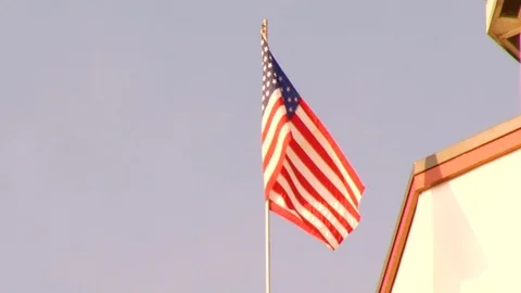 American flags waving in the wind on top of red and white lighthouse B Stock Footage 117249282