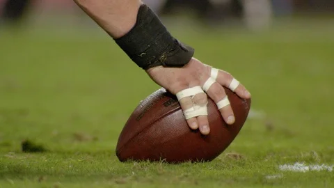 American football player center snaps the ball during game Stock Footage