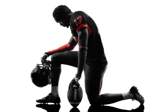 American football player kneeling silhouette Stock Photos