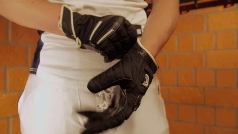 American football player puts on gloves Stock Footage