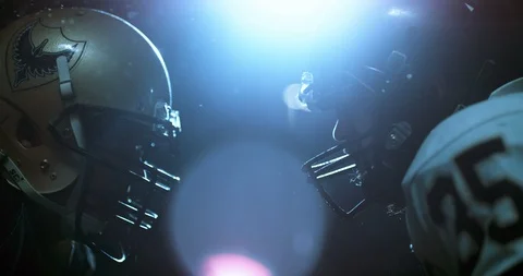 American football players in stadium at night during game Stock Footage