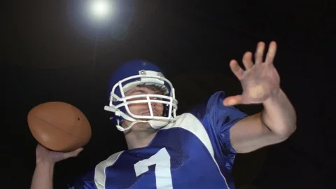 American Football Quarterback throwing the ball. Black Background. Slow motion. Stock Footage