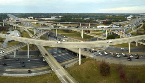 American freeway intersection with fast driving cars and trucks. View from above Stock Photos