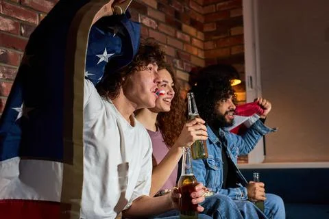 American friends drinking beer while cheering for favourite team on football Stock Photos