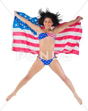 American girl in bikini leaping holding flag Stock-Fotos