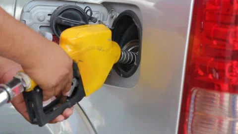 American guy holding nozzle in hand during refuel process Gasoline, gas, Stock Footage 336569424