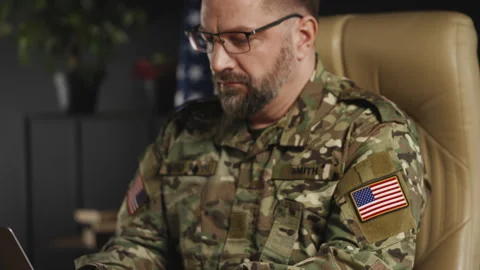 American intelligence officer working on laptop in office, preparing reports Stock Footage 334668147