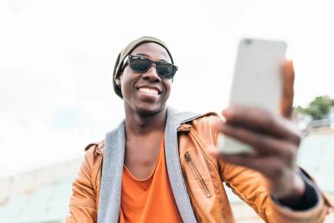 American man using mobile in the street. Stock Photos
