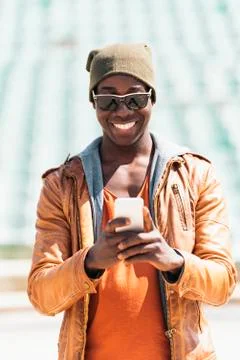 American man using mobile in the street. Stock Photos
