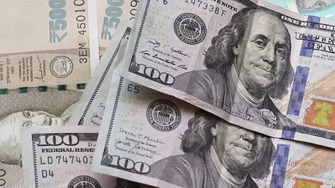 American one hundred dollar banknotes are placed on top of Indian rupees Stock Footage 302582152