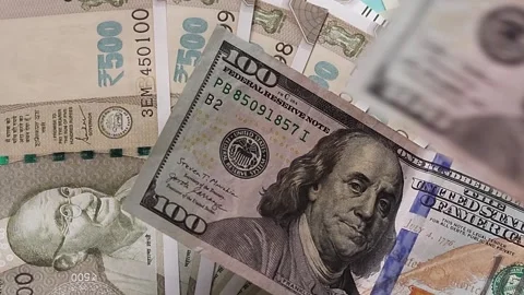 American one hundred dollar banknotes are placed on top of Indian rupees Stock Footage 302582159