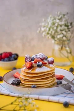 American pancakes with berries and maple syrup. Homemade summer breakfast. Stock Photos