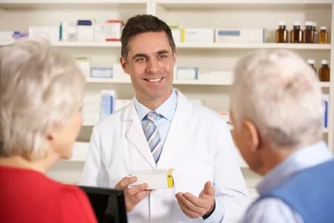 American pharmacist with senior couple in pharmacy Stock Photos