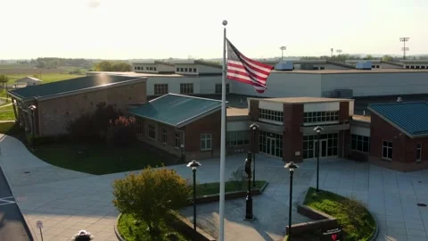 American school building stands empty under American flag during magic Video stock 130567096
