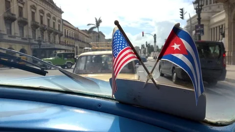 American sentiments in Cuba. US &amp; Cuba flags on the windshield of a vintage car Stock Footage 70550054